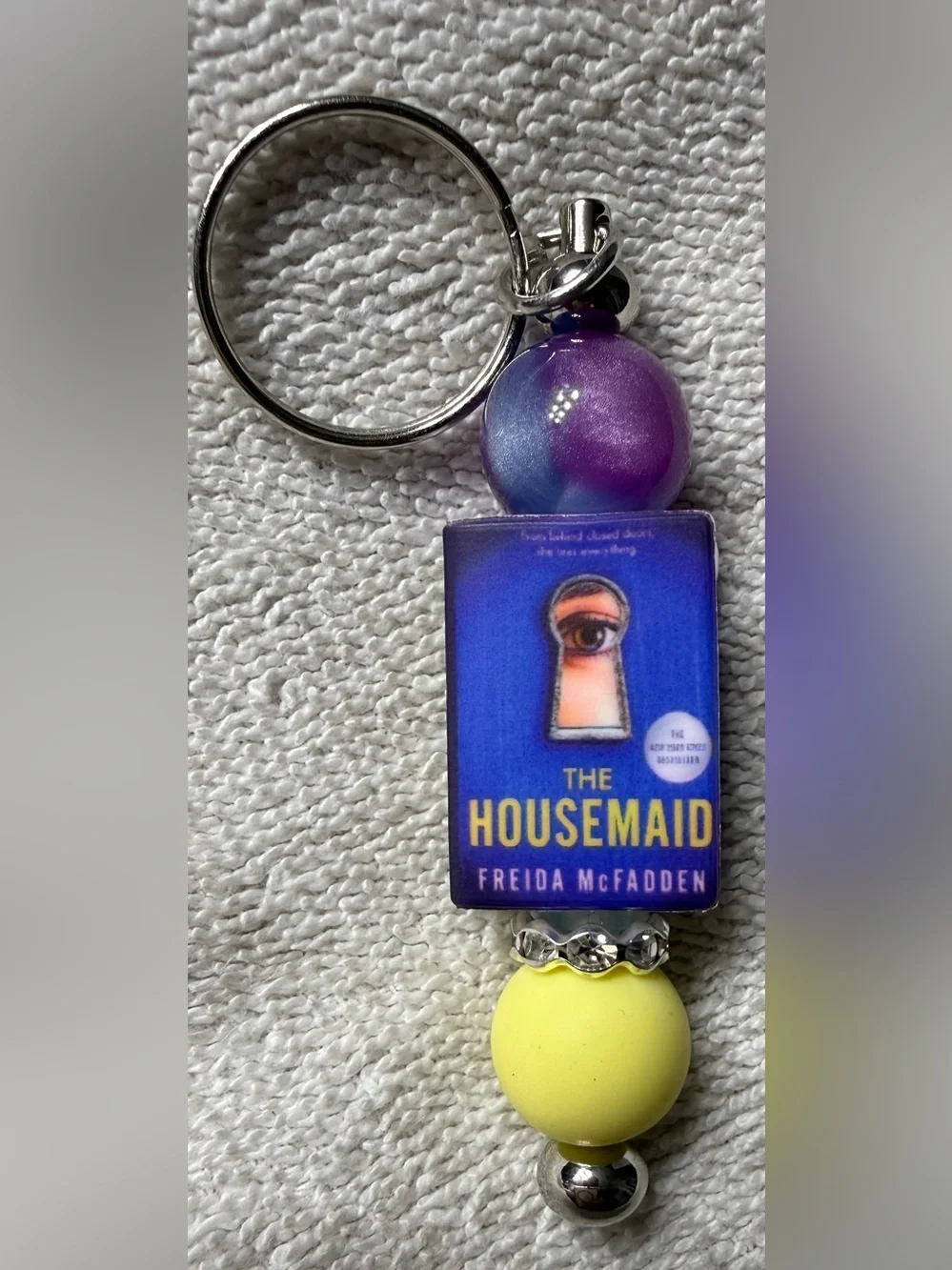 The Housemaid Book Cover Keychain in Purple & Yellow
